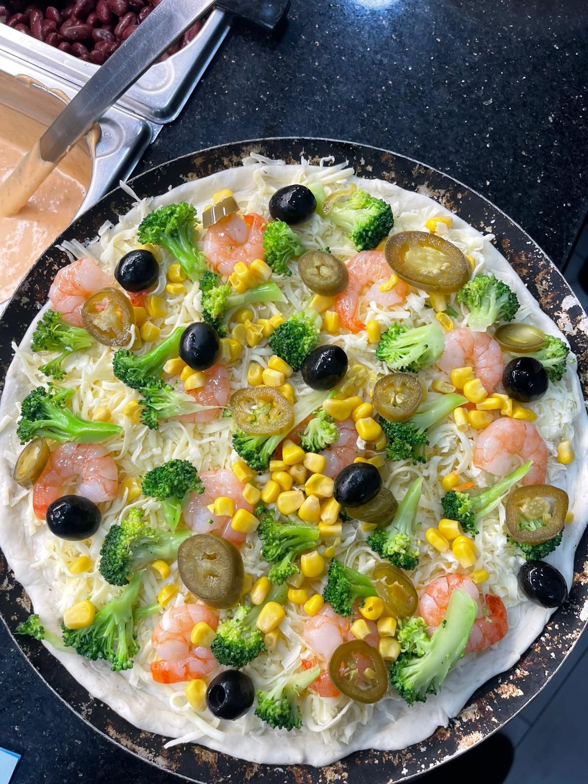 Pizza mit Garnelen und Broccoli belegt